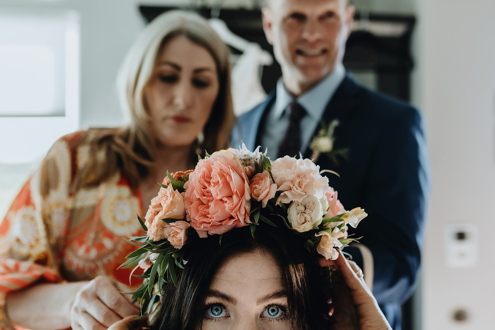 A woman is arranging a flower hair band on the bride