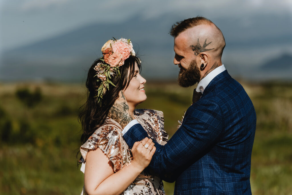 Woman wearing a flower hair band smiling at her husband and the husband smiles back