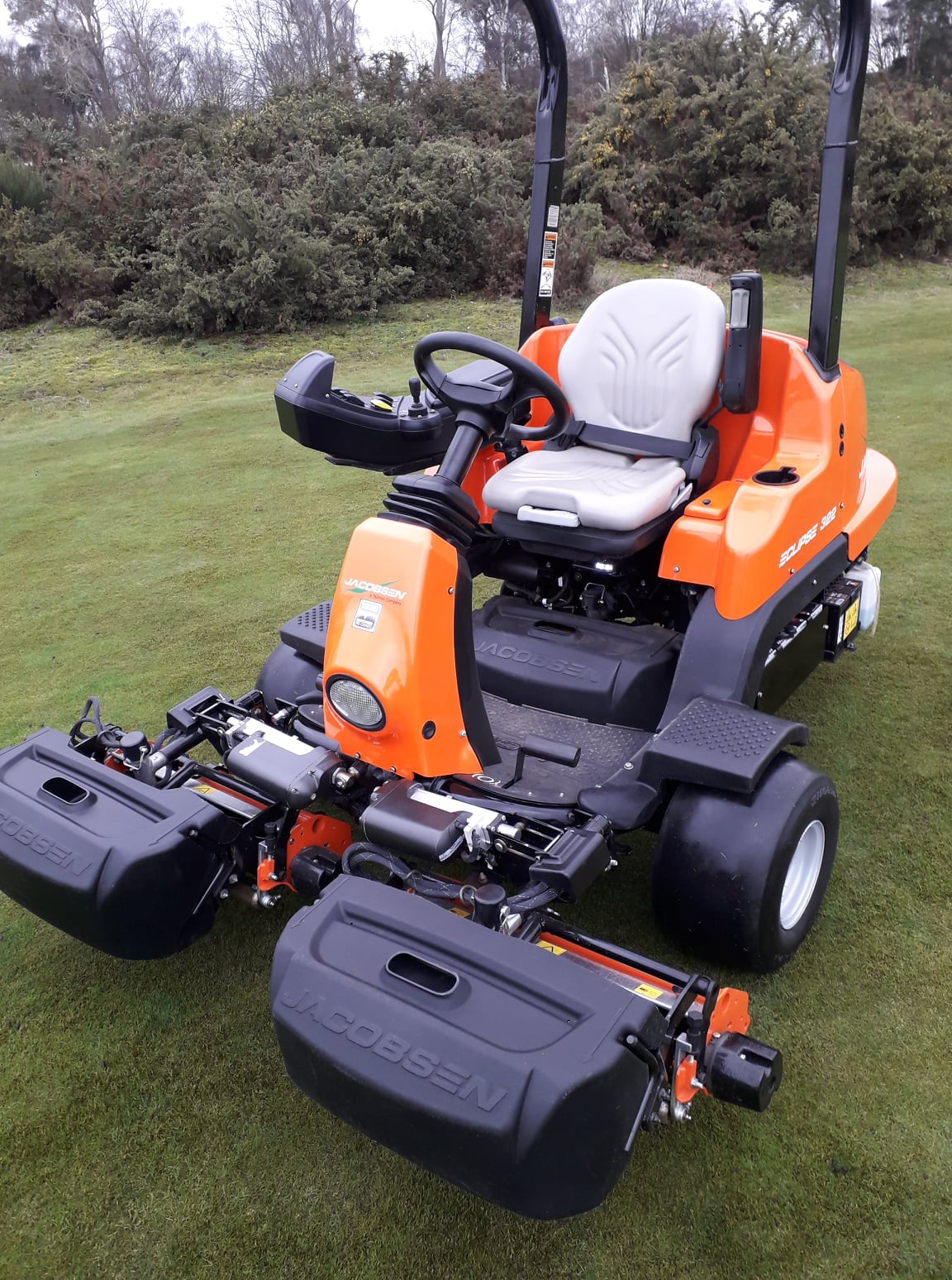 Golf course mower on a green field